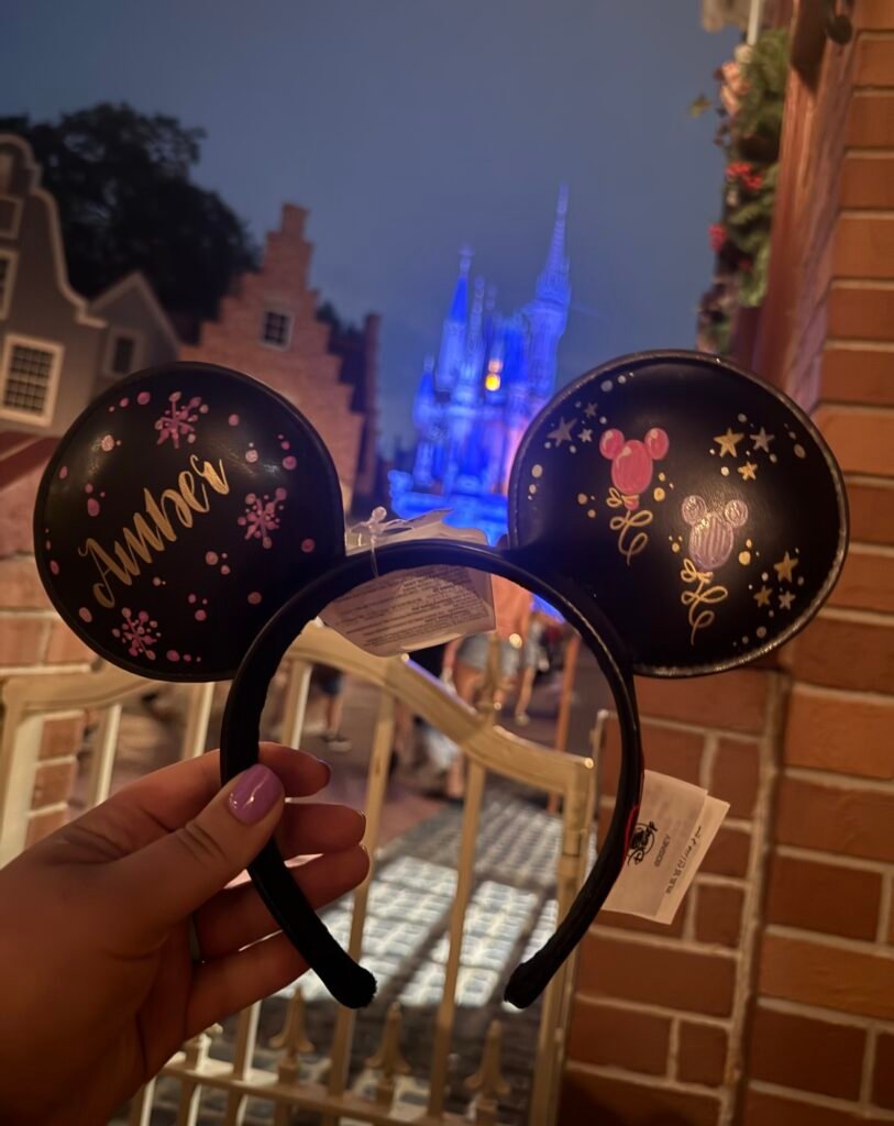 Personalized Mickey ears in front of a glowing Cinderella's Castle.