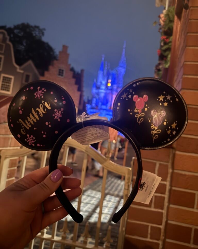 Personalized Mickey ears in front of a glowing Cinderella's Castle.